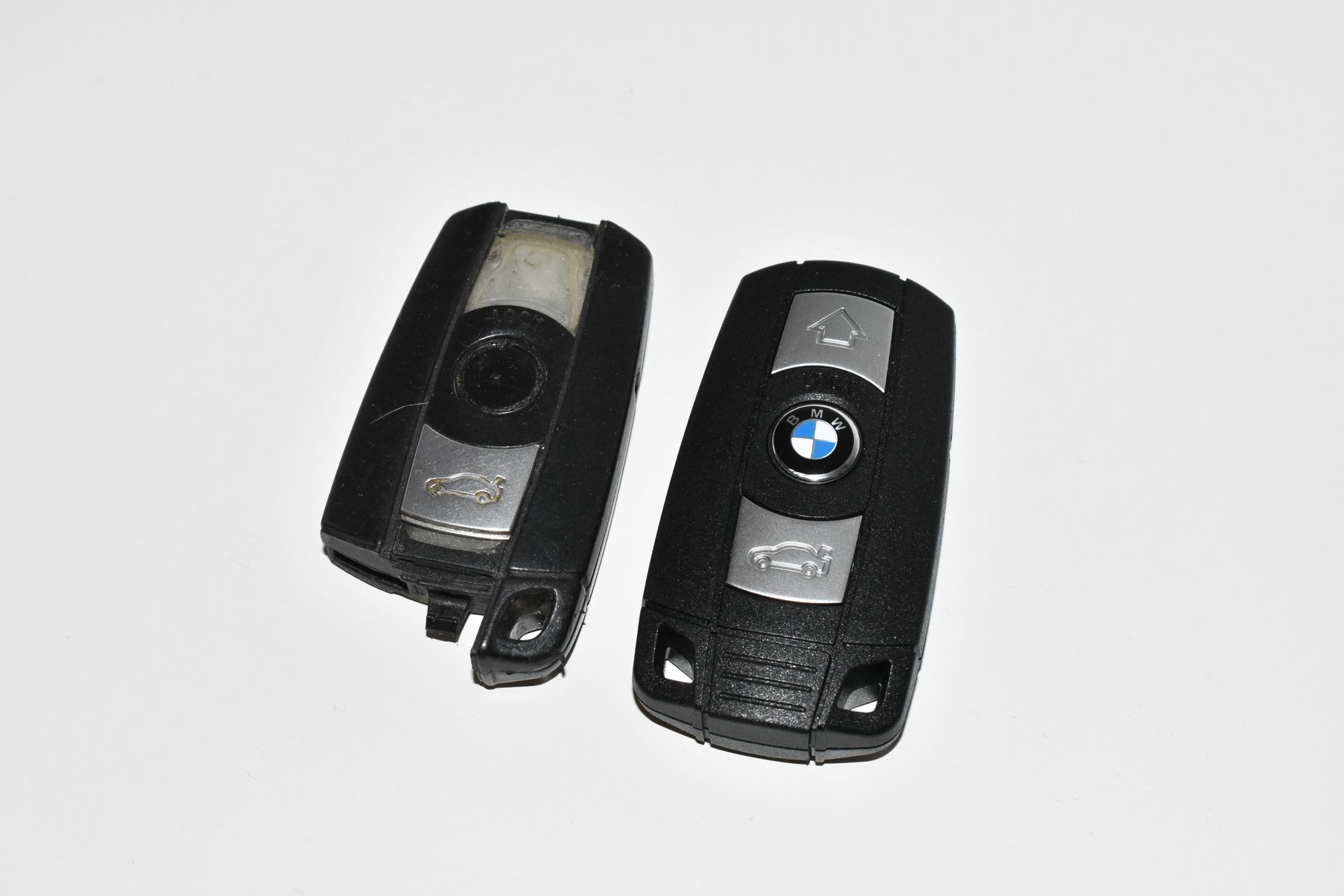 Two different BMW car key fobs placed side by side on a white background.